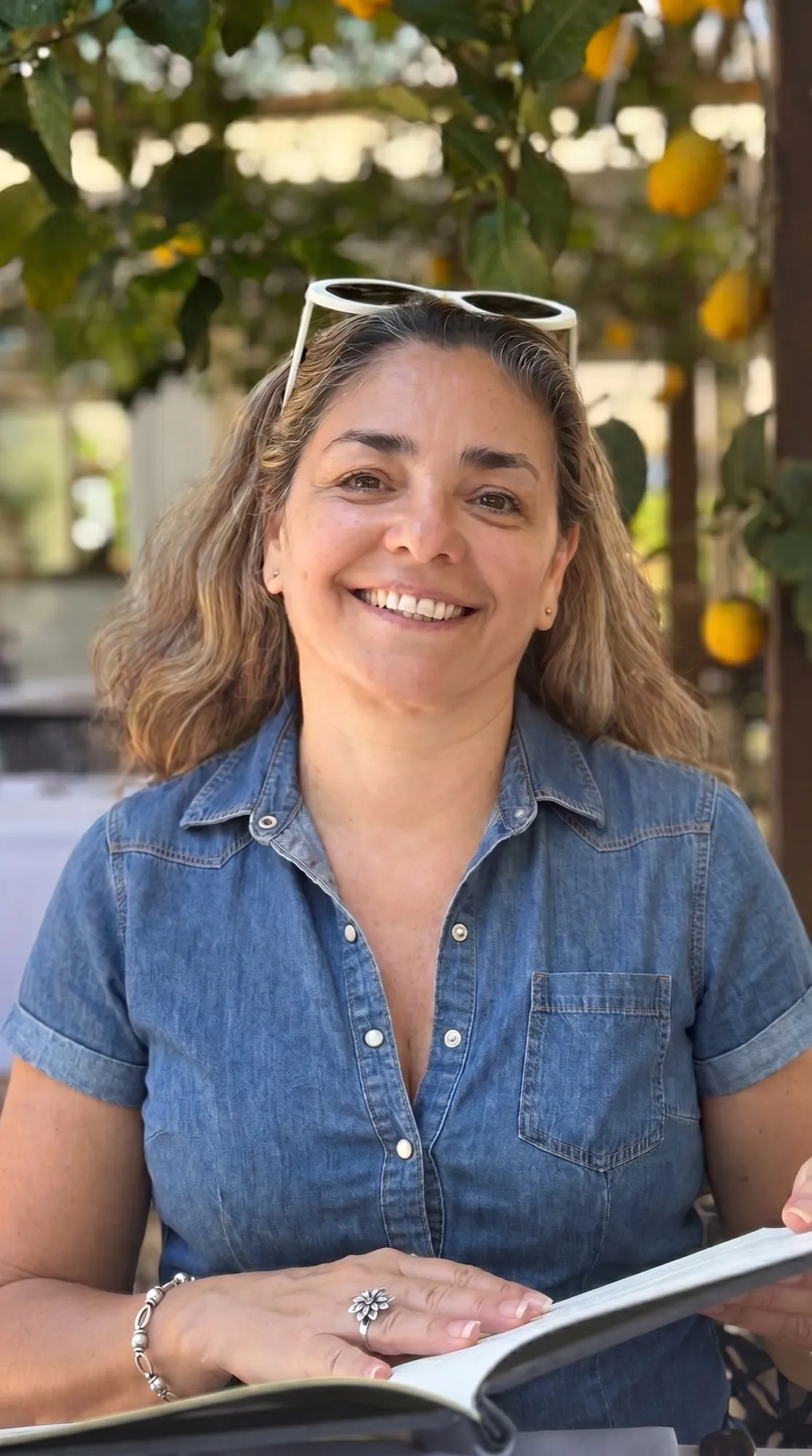 Georgina Ghiorzi sonriendo bajo un limonero, con los limones en las ramas